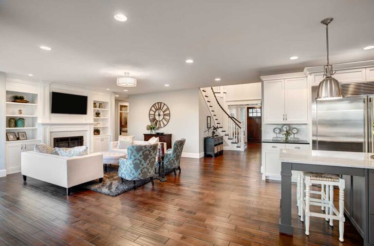 A young couple reviewing a house checklist and inspecting a home's kitchen together.